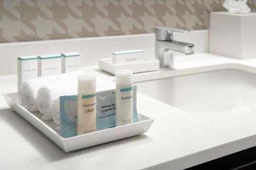 a bathroom counter with a sink with products on it at Home2 Suites By Hilton Edison in Edison