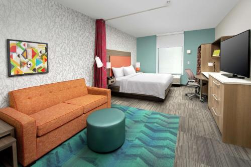 a hotel room with a couch and a bed at Home2 Suites By Hilton Edison in Edison