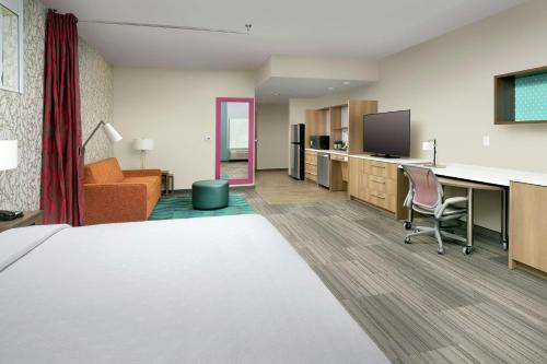 a hotel room with a bed and a desk at Home2 Suites By Hilton Edison in Edison