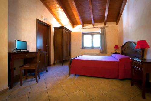 a bedroom with a bed and a desk and a computer at Agriturismo U' Casinu dà Scala in Campora San Giovanni
