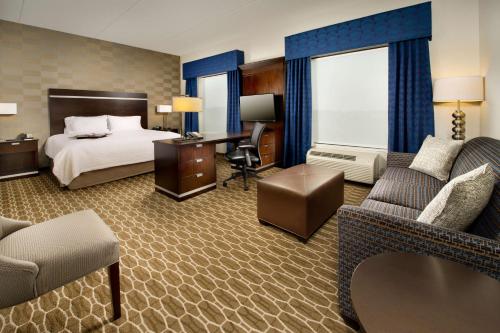 a hotel room with a bed and a desk and chairs at Hampton Inn and Suites Washington DC North/Gaithersburg in Gaithersburg