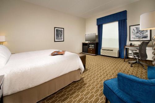 una camera d'albergo con letto, scrivania e sedia di Hampton Inn and Suites Washington DC North/Gaithersburg a Gaithersburg