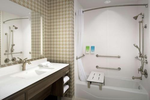 a bathroom with a sink and a tub and a shower at Home2 Suites by Hilton San Antonio Lackland SeaWorld in San Antonio