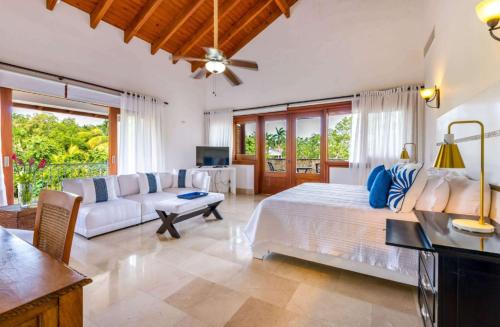 Sunny vacation Villa No 76 في San Rafael del Yuma: غرفة نوم كبيرة مع سرير وأريكة