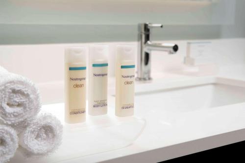 a bathroom sink with three tubes of sunscreen on it at Homewood Suites San Antonio Airport in San Antonio