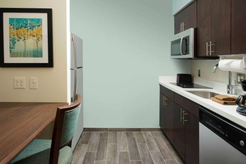 a kitchen with a refrigerator and a counter top at Homewood Suites San Antonio Airport in San Antonio