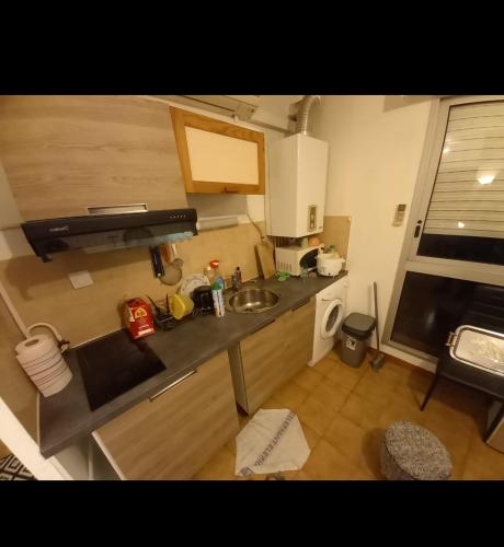 uma pequena cozinha com um lavatório e uma bancada em idéal pour vacances et affaires em Perpignan