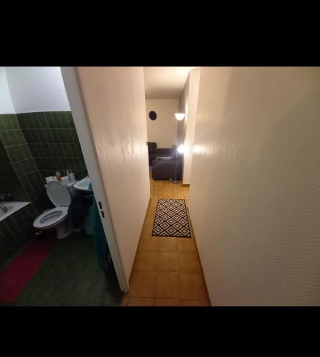 a hallway to a bathroom with a toilet and a sink at idéal pour vacances et affaires in Perpignan