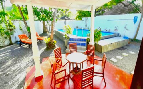 a patio with a table and chairs and a pool at Calm Villa Wadduwa in Wadduwa