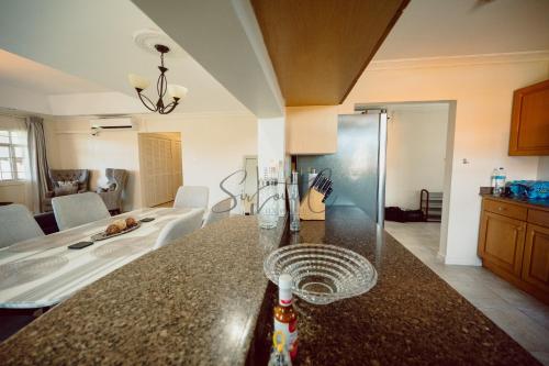 a kitchen with a counter top and a room at Executive Three Bedroom Condo on the Greens in Trincity 