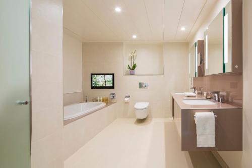 a bathroom with two sinks and a tub and a toilet at COMO Metropolitan London in London