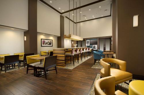 a restaurant with chairs and tables and a bar at Hampton Inn & Suites Syracuse/Carrier Circle in East Syracuse