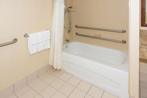 Habitación con baño con bañera blanca. en Hilton Garden Inn Buffalo Airport en Cheektowaga