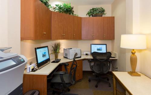 um escritório com uma secretária com um computador e dois monitores em Hilton Garden Inn Buffalo Airport em Cheektowaga