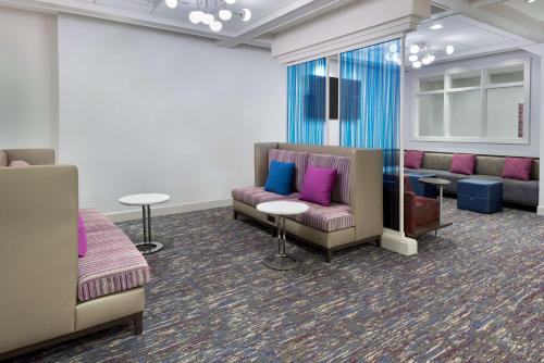 a waiting room with couches and tables and purple pillows at Hampton Inn & Suites Buffalo/Downtown in Buffalo