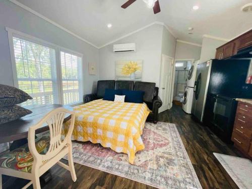 a bedroom with a bed and a kitchen with a refrigerator at Small Home near Lake Fork with Stocked Pond in Emory
