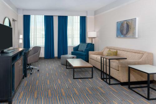 a living room with a couch and a tv at Hampton Inn & Suites Buffalo/Downtown in Buffalo