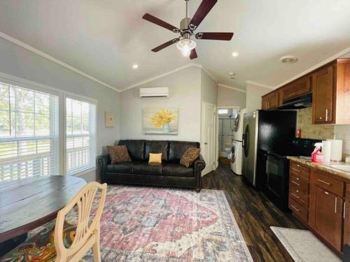 uma sala de estar com um sofá preto e uma cozinha em Small Home near Lake Fork with Stocked Pond em Emory
