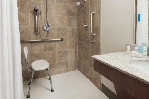 a shower with a chair in a bathroom at Hampton Inn Danbury in Danbury