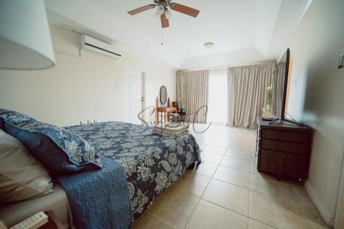 a bedroom with a bed and a television in it at Executive Three Bedroom Condo on the Greens in Trincity 
