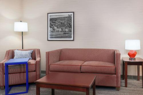 a living room with a couch and a chair at Hampton Inn Springfield South Enfield in Enfield
