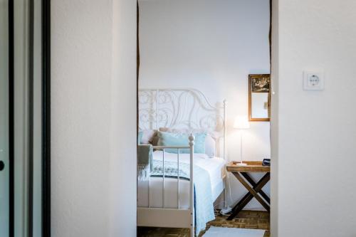 um quarto com uma cama branca e uma mesa em Seenswert - Vegane Pension und Ferienwohnungen am Ammersee em Pähl