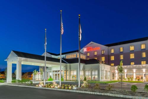 a hotel with two flags in front of a building at Hilton Garden Inn Wayne in Wayne