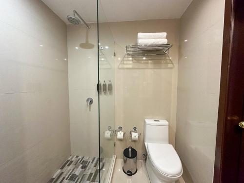 a bathroom with a toilet and a glass shower at La Quinta by Wyndham Quito in Quito