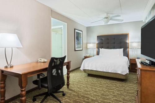 a hotel room with a bed and a desk with a computer at Homewood Suites by Hilton Holyoke-Springfield/North in Holyoke