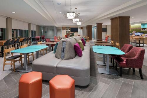 a waiting area with tables and a couch at Home2 Suites By Hilton Orlando Near UCF in Orlando