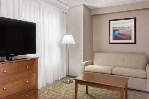 a living room with a couch and a flat screen tv at Homewood Suites by Hilton Holyoke-Springfield/North in Holyoke