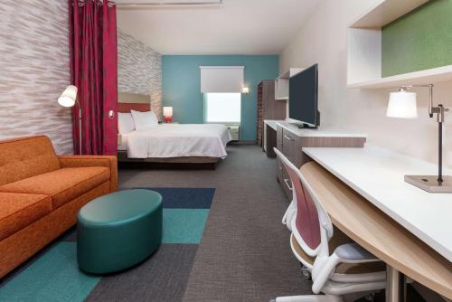 奥兰多Home2 Suites By Hilton Orlando Near UCF的配有床和沙发的酒店房间