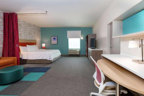 a hotel room with a bed and a desk at Home2 Suites By Hilton Orlando Near UCF in Orlando
