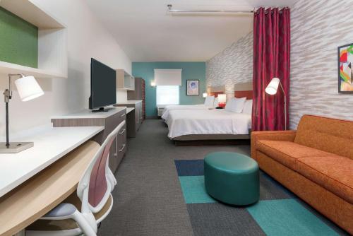 a hotel room with a bed and a couch at Home2 Suites By Hilton Orlando Near UCF in Orlando