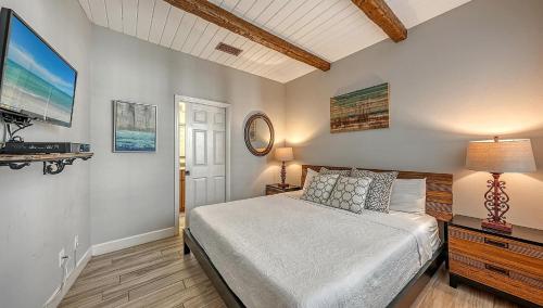 1 dormitorio con 1 cama y TV de pantalla plana en Villa Castile - 5204, en Siesta Key