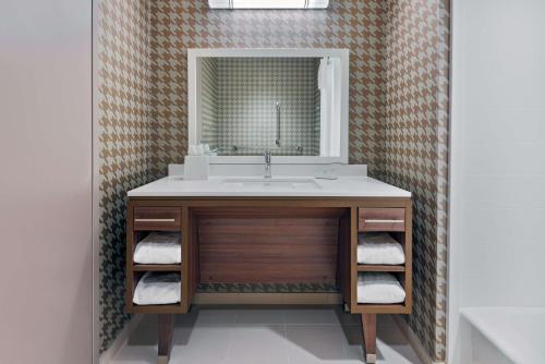 Home2 Suites By Hilton Orlando Near Universal في أورلاندو: حمام مع حوض ومرآة