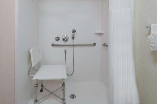 a white shower with a white chair in a bathroom at Hampton Inn South Plainfield-Piscataway in South Plainfield