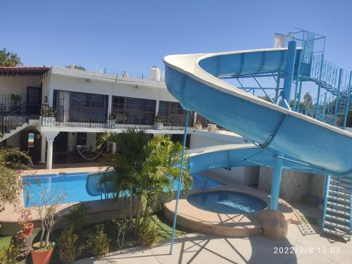a slide in front of a resort with a boat on it at Mansion Serrano Hotel in El Fuerte