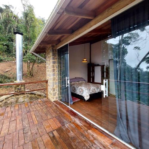 a balcony of a house with a bed in it at Chalé dos Altos de Laranjeiras in Paraty