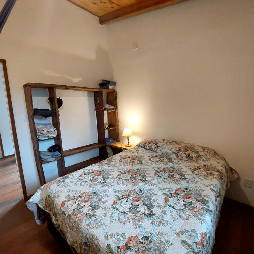 a bedroom with a bed and a shelf with shoes at Chalé dos Altos de Laranjeiras in Paraty