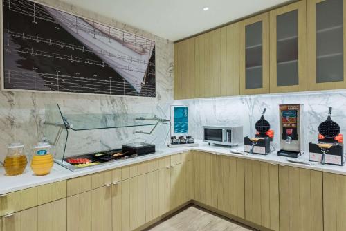 cocina con armarios de madera y encimera con microondas en Homewood Suites by Hilton Sarasota-Lakewood Ranch, en Sarasota