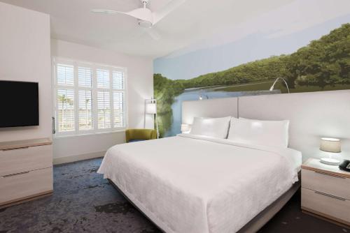 1 dormitorio con 1 cama blanca grande y TV en Homewood Suites by Hilton Sarasota-Lakewood Ranch, en Sarasota