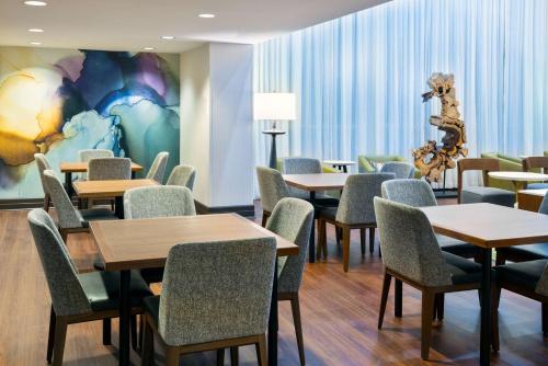 a waiting room with tables and chairs and a mural at Hampton Inn and Suites Sarasota/Lakewood Ranch in Sarasota