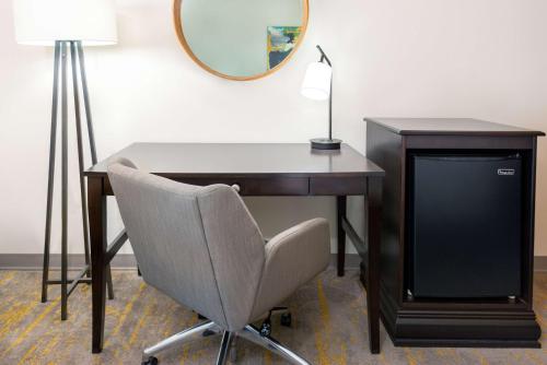 a desk with a tv and a chair and a mirror at Hampton Inn and Suites Sarasota/Lakewood Ranch in Sarasota