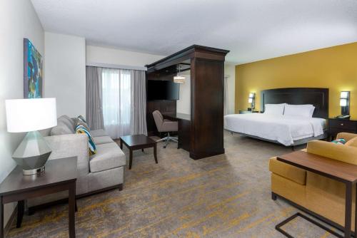サラソタにあるHampton Inn and Suites Sarasota/Lakewood Ranchのベッドとソファ付きのホテルルーム