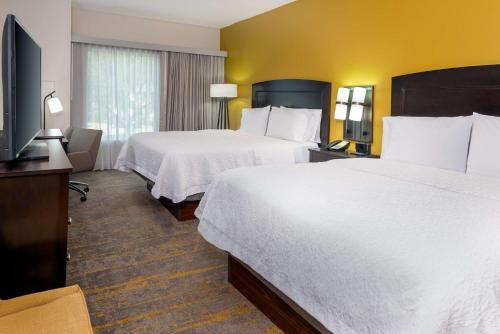 a hotel room with two beds and a flat screen tv at Hampton Inn and Suites Sarasota/Lakewood Ranch in Sarasota