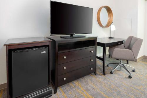 a television on a dresser with a desk and a chair at Hampton Inn and Suites Sarasota/Lakewood Ranch in Sarasota