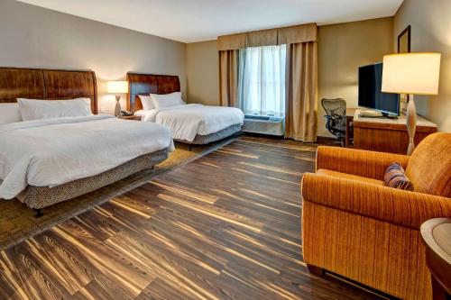 a hotel room with two beds and a couch at Hilton Garden Inn Nashville Brentwood in Brentwood