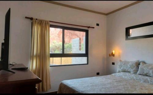 1 dormitorio con cama y ventana en CASA de PURMAMARCA en Purmamarca