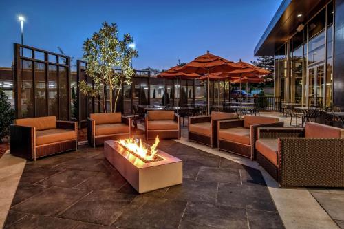 a patio with a fire pit and chairs and tables at Hilton Franklin Cool Springs in Franklin